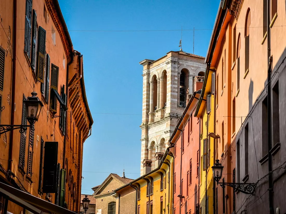 Ferrara historic centre with cathedral tower above painted houses