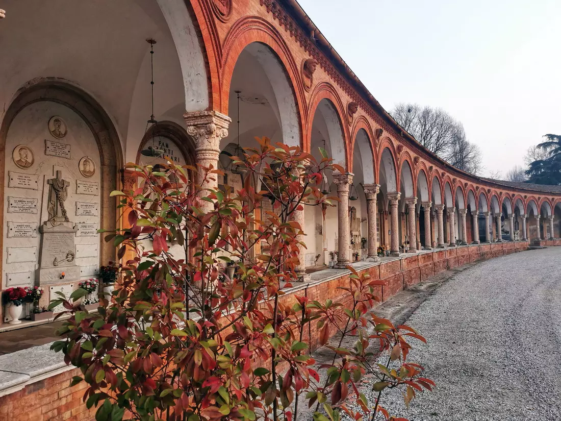 Shaded arcade with tombs and sculptures in the Certosa di Ferrara