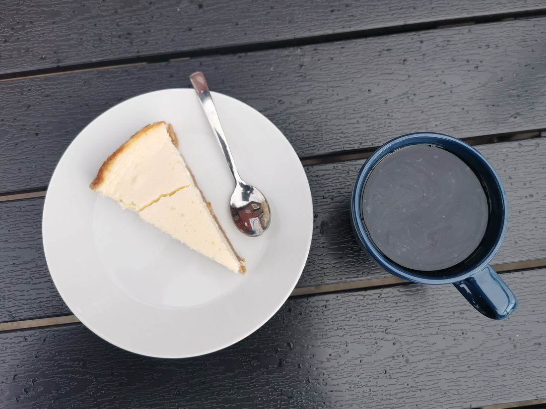 Coffee and cheesecake on a rain-covered table in Åland