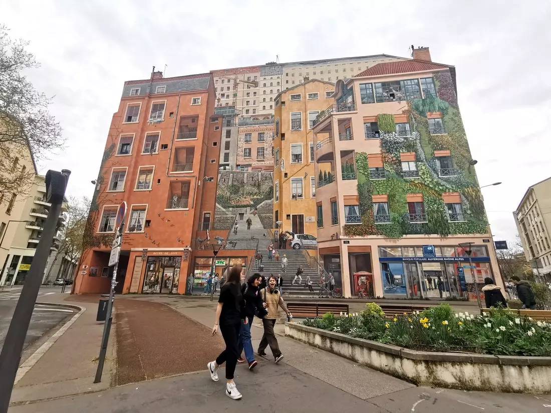 Mural in Croix-Rousse showing people on balconies, steps, and in a café.
