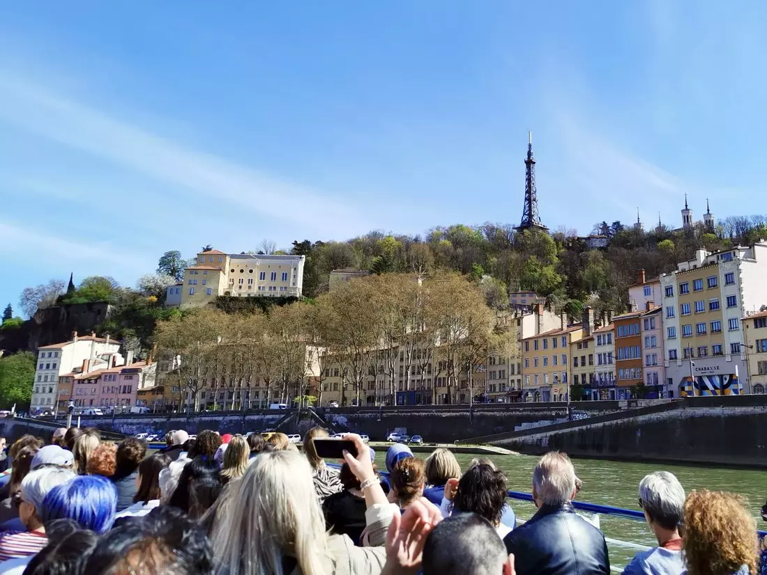 Tour boat on the Saône in Lyon, packed on both decks with passengers enjoying the view.