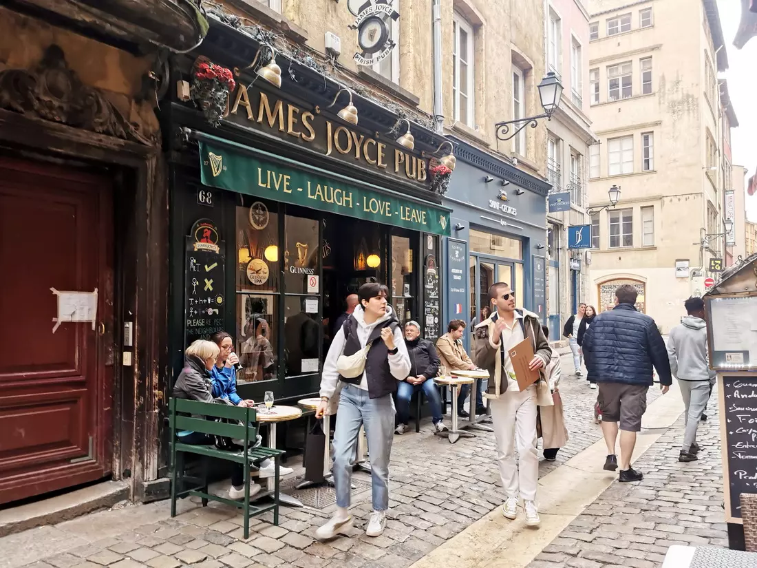 Narrow cobbled street in Vieux Lyon with traditional cafés, bouchons, and local shops.
