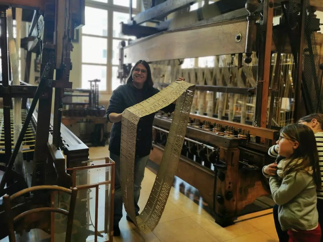 Close-up of a perforated Jacquard card used in traditional silk weaving at Atelier de Soierie in Lyon.