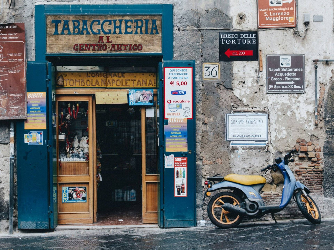 Front view of an Italian tabaccheria with a rustic exterior, vintage signage