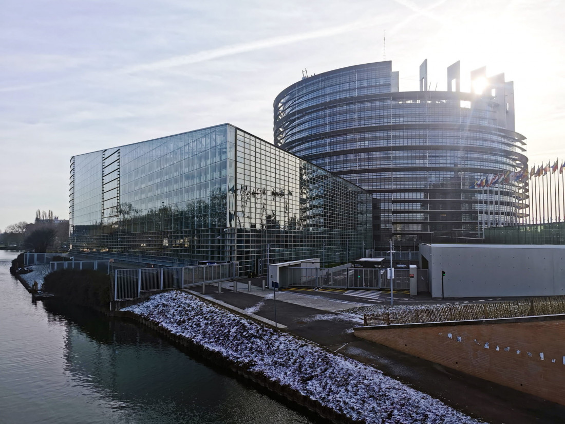 The glass facade of the European Parliament (Louise Weiss building) in Strasbourg overlooking the Ill river in winter.