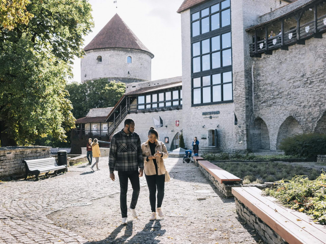 People walking through a quiet Old Town courtyard in Tallinn near medieval stone walls