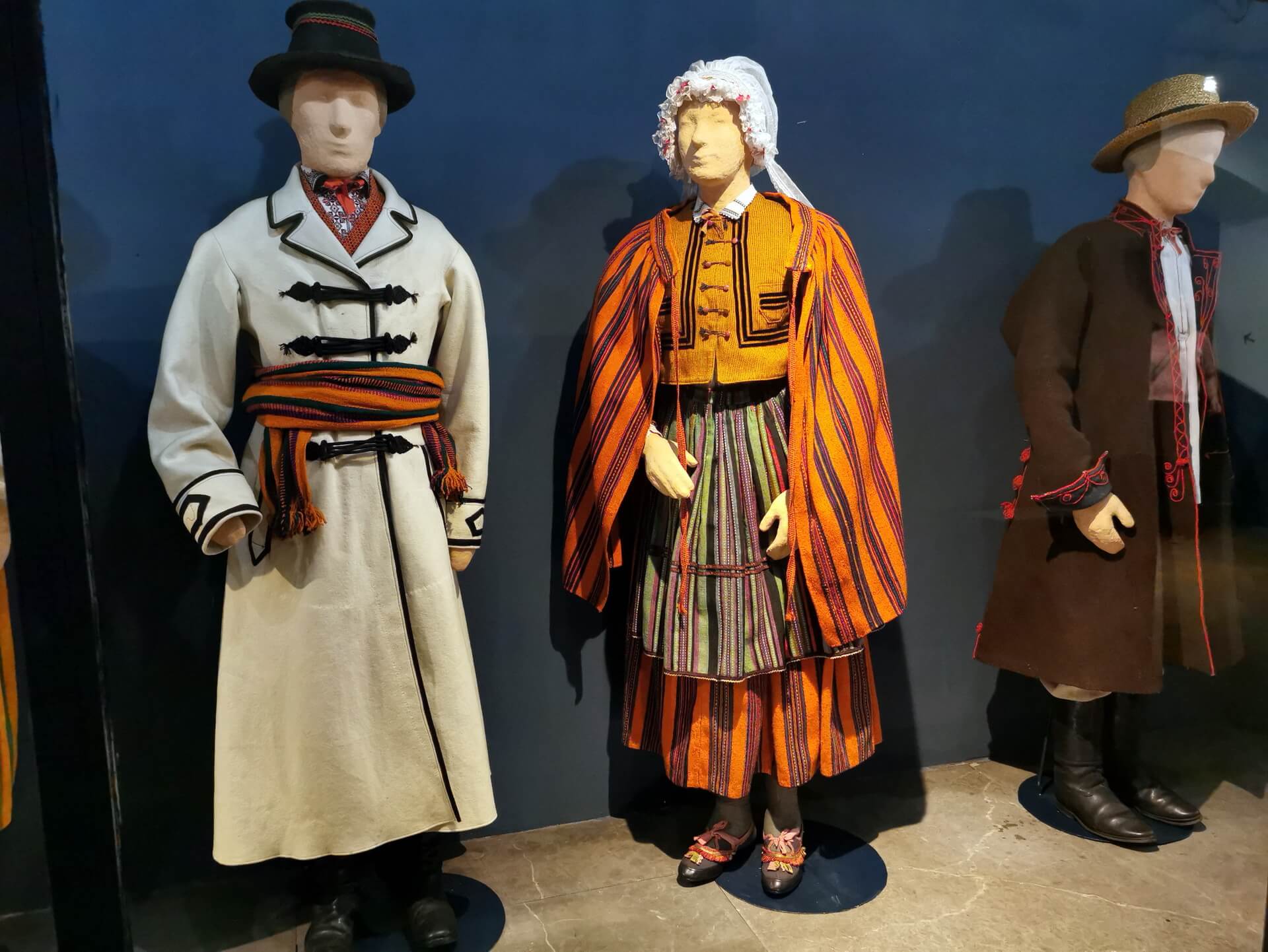 Krakow regional outfits displayed against a dark blue wall