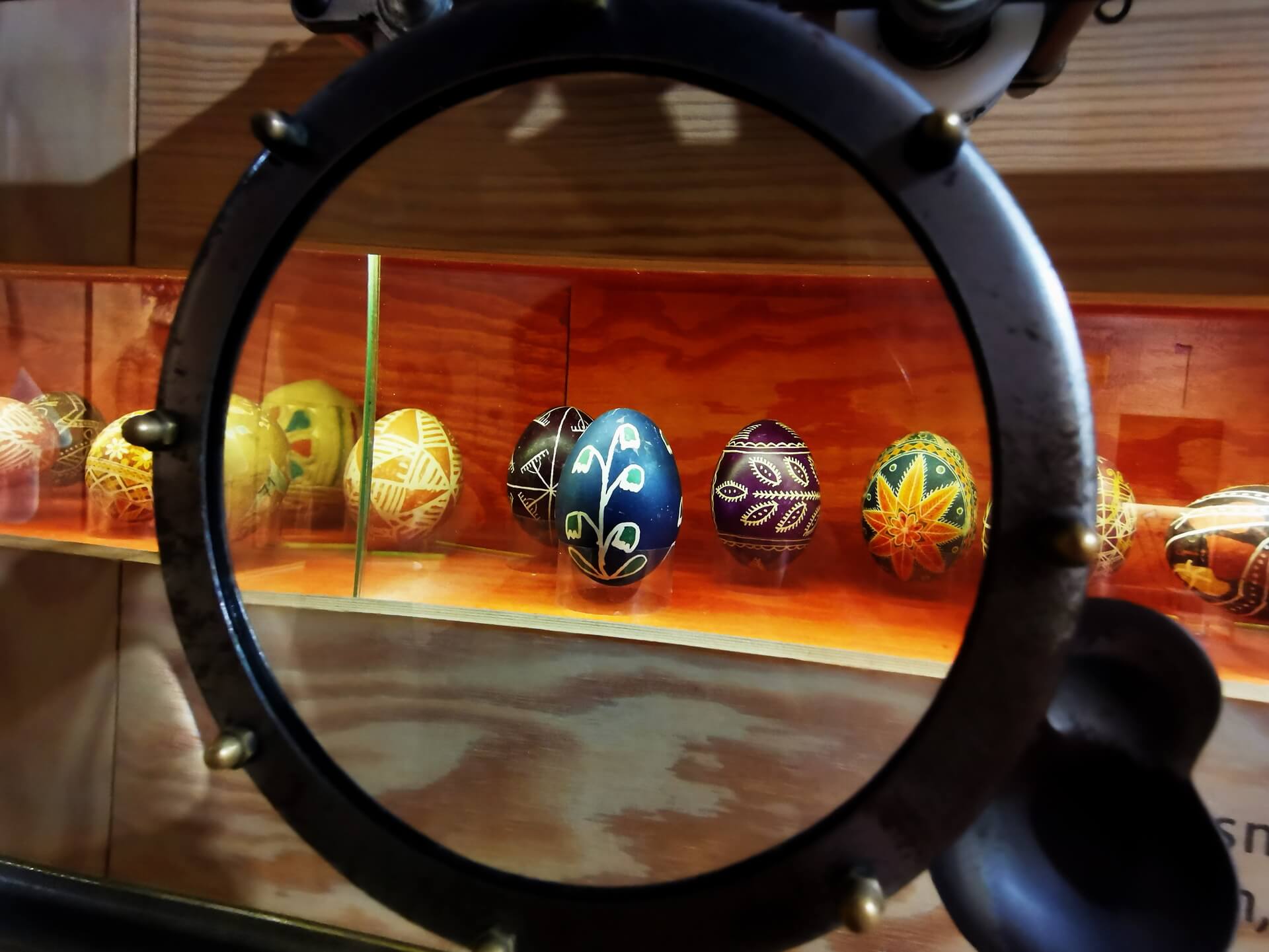 Traditional Polish pisanki Easter eggs displayed behind a magnifying glass at the Ethnographic Museum in Krakow