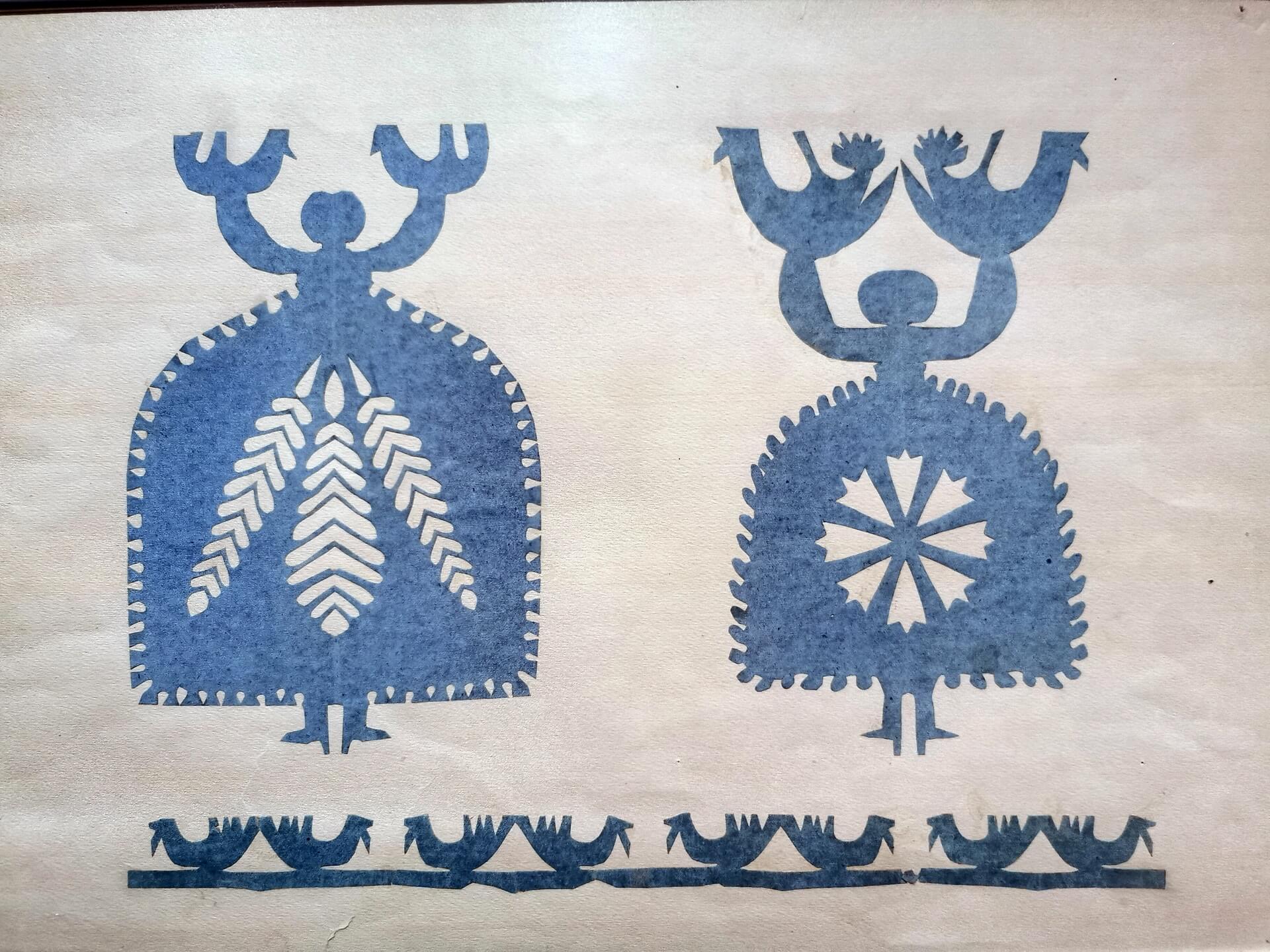 Blue symmetrical wycinanki paper cut with birds and floral motifs