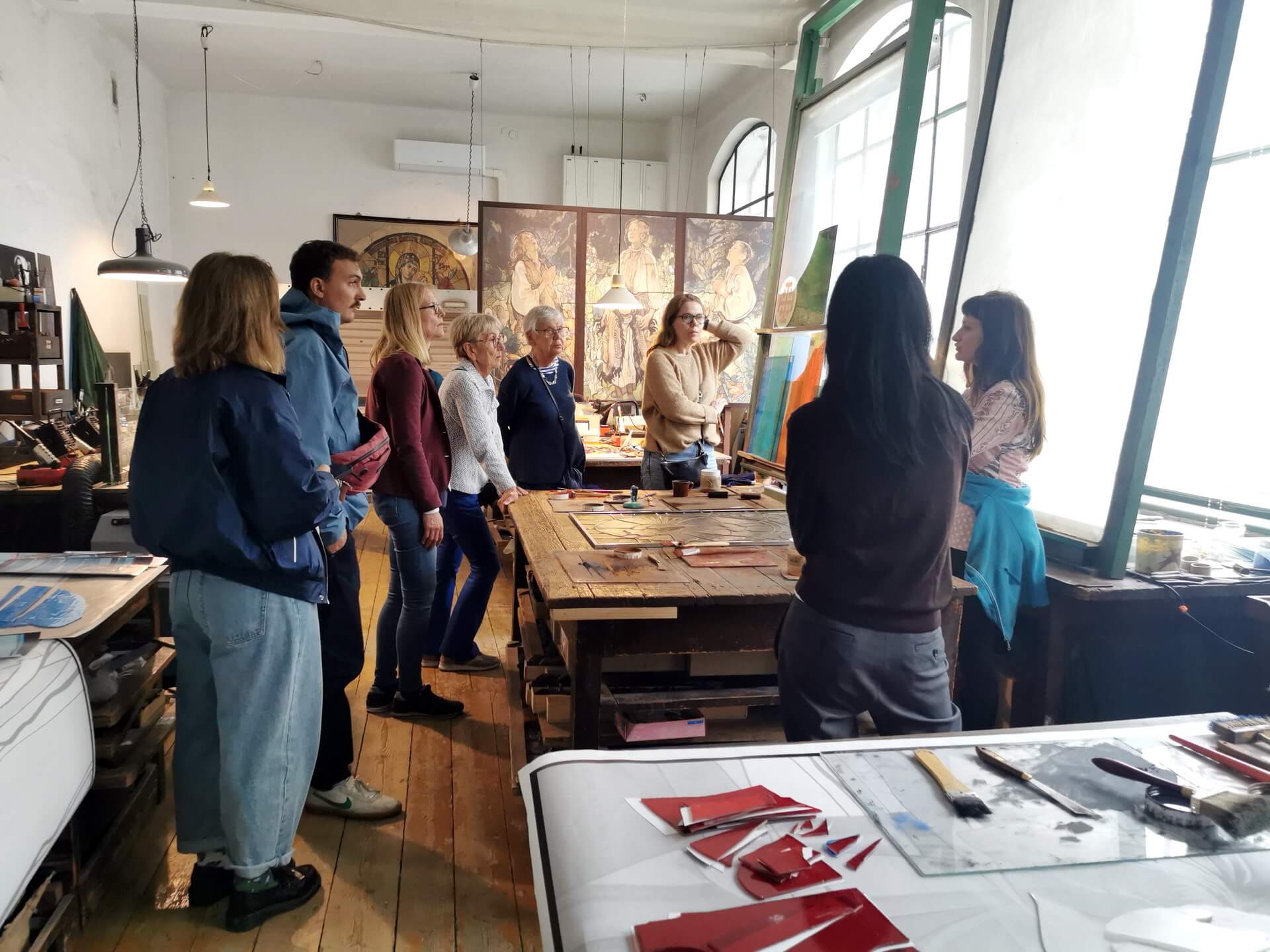 tour group watching a stained glass demonstration