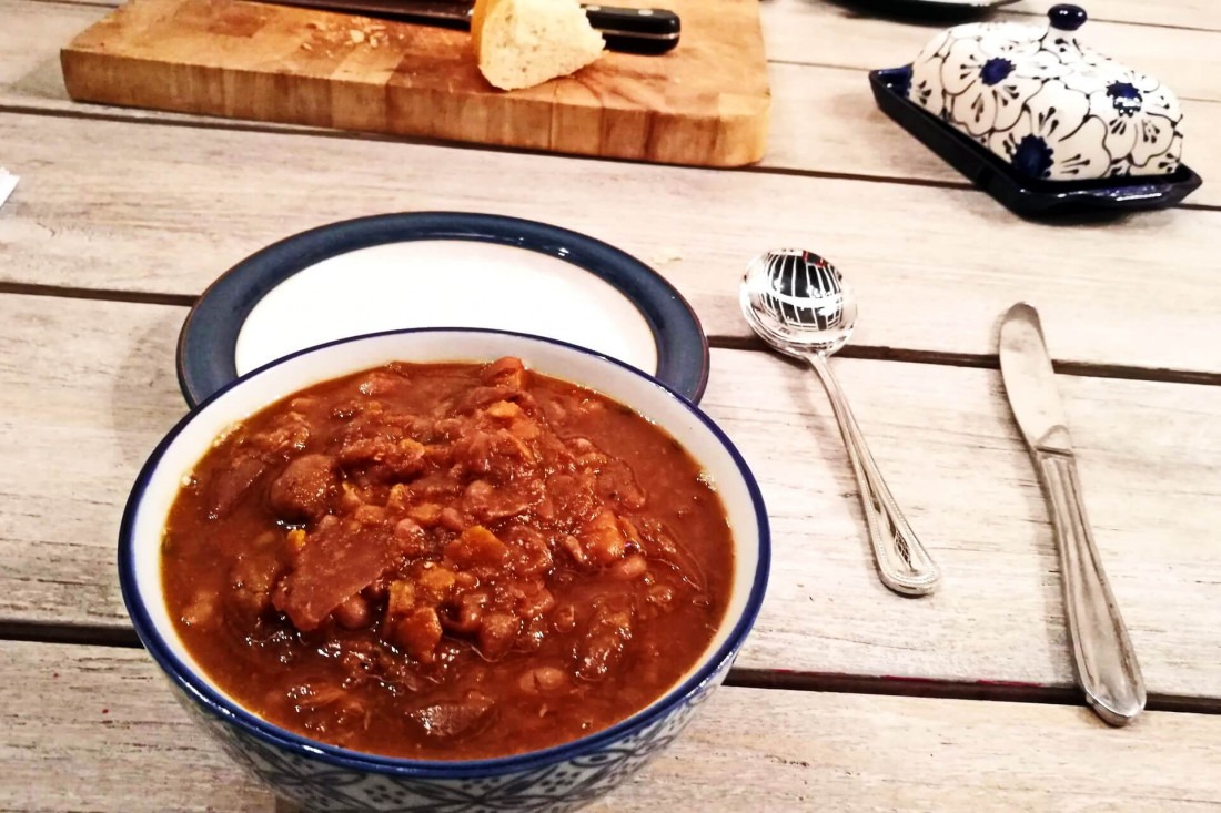 A bowl of vegetarian Guernsey Bean Jar, a thick and deeply savoury slow-cooked bean stew.